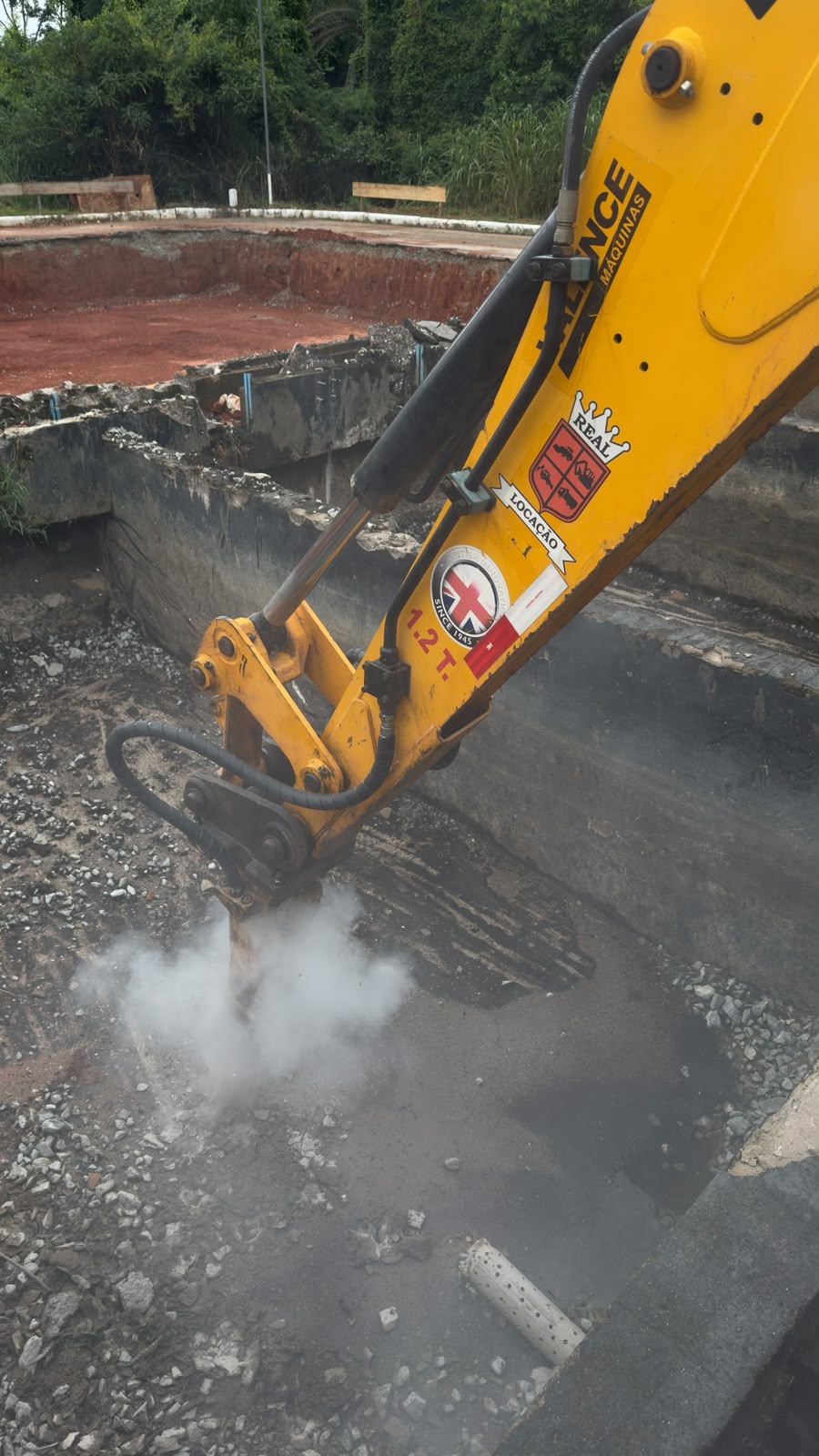 Escavadeira Valence com rompedor demolindo estrutura de concreto