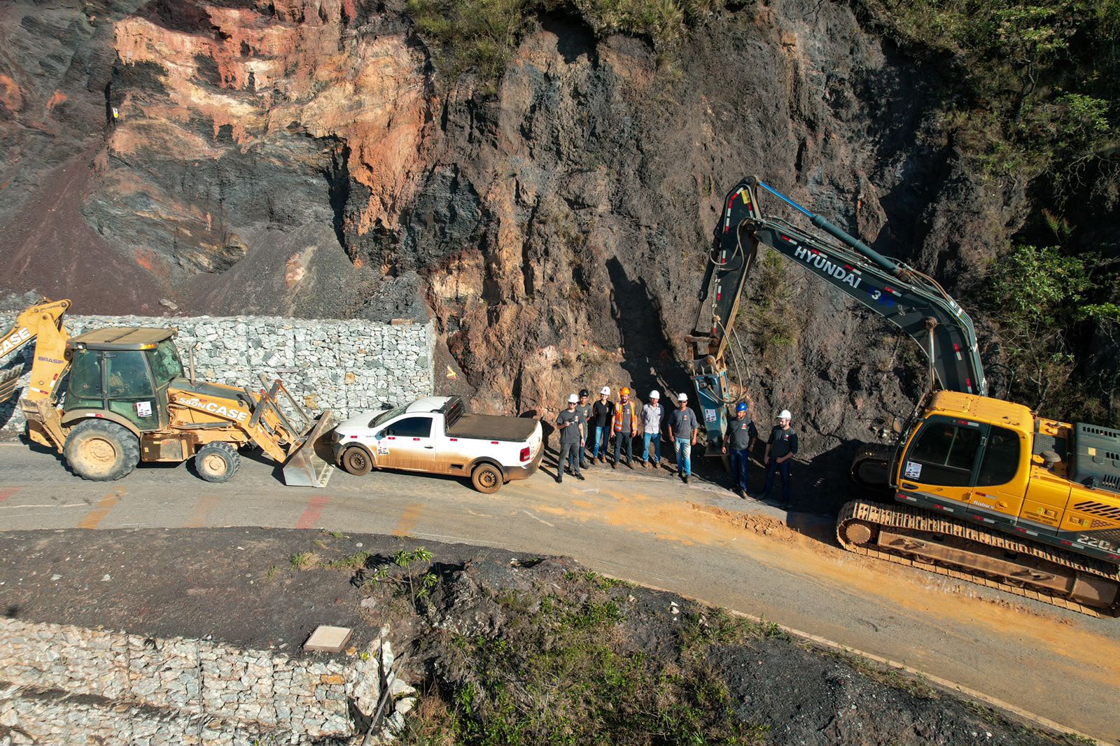 Vista aérea de escavadeira Hyundai e retroescavadeira CASE em obra de contenção